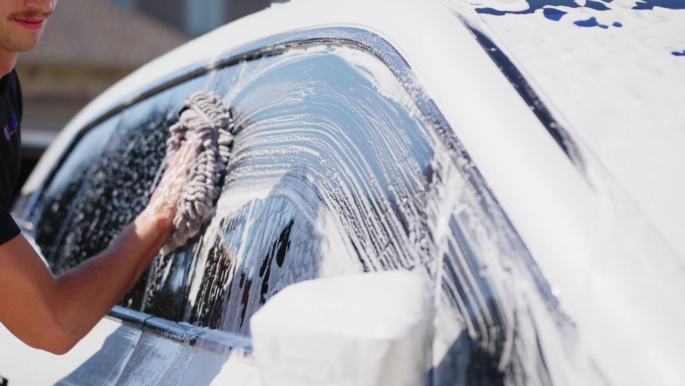 Hand washing a white vehicle before paint correction