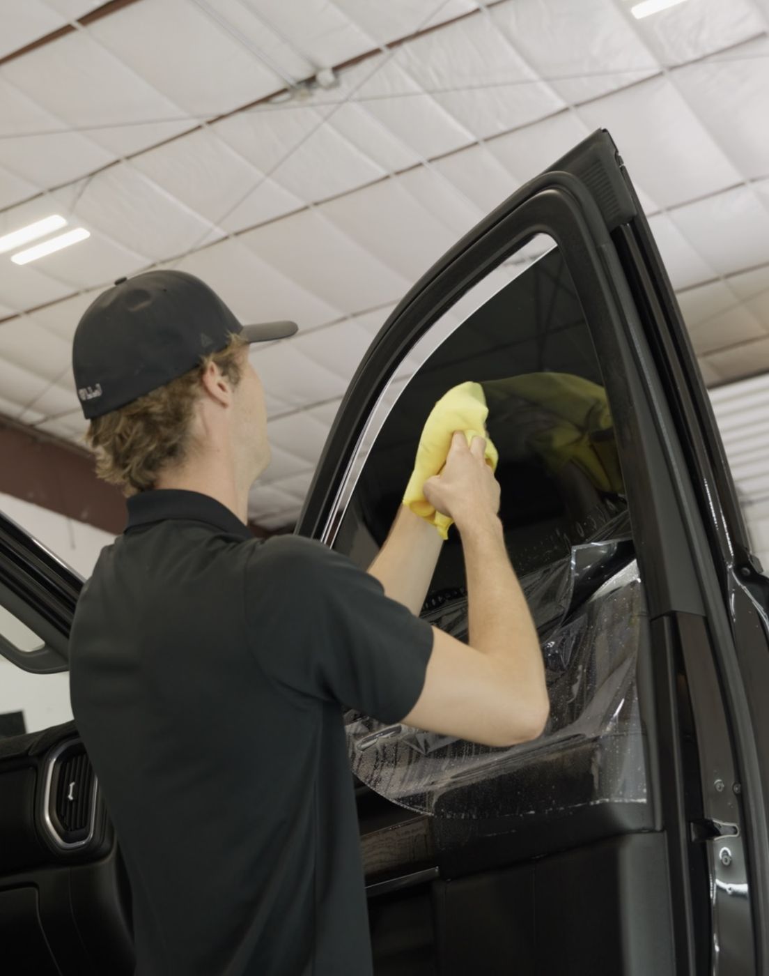 Xavier installer fitting ceramic tint to a front door window