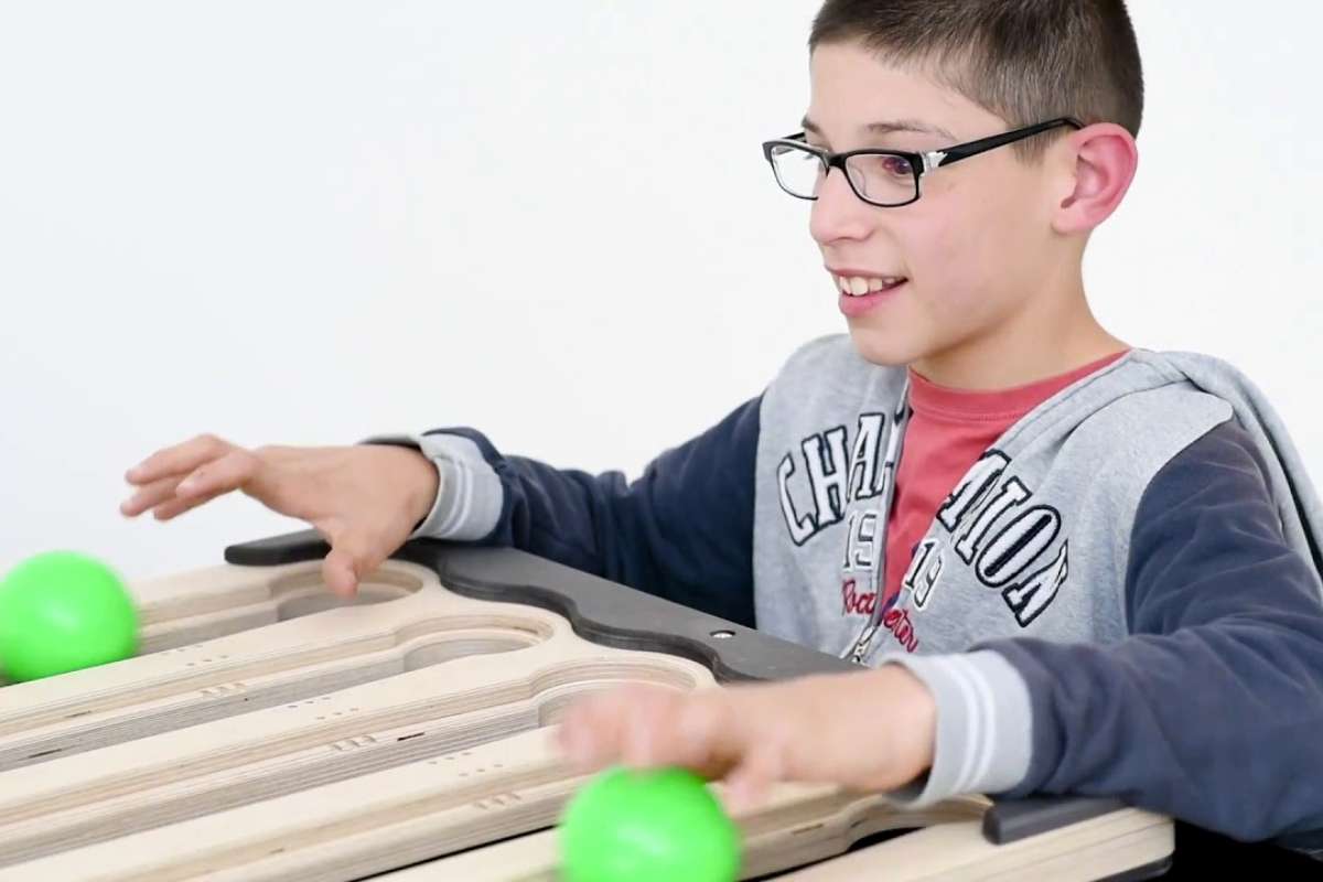 Young learner engaged with the Juggle Board, smiling