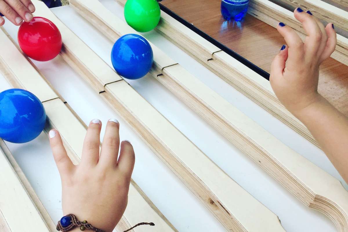 Close-up of hands on the Juggle Board with balls rolling