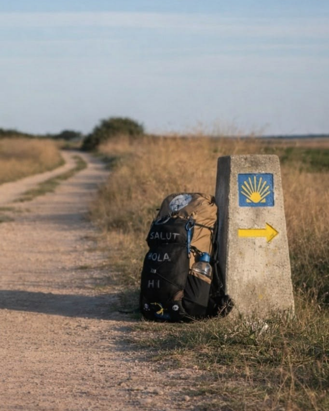 Mojón del Camino con la concha y la flecha amarilla