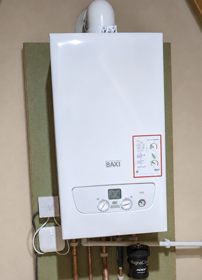 Wall-mounted boiler installation with heating system filter