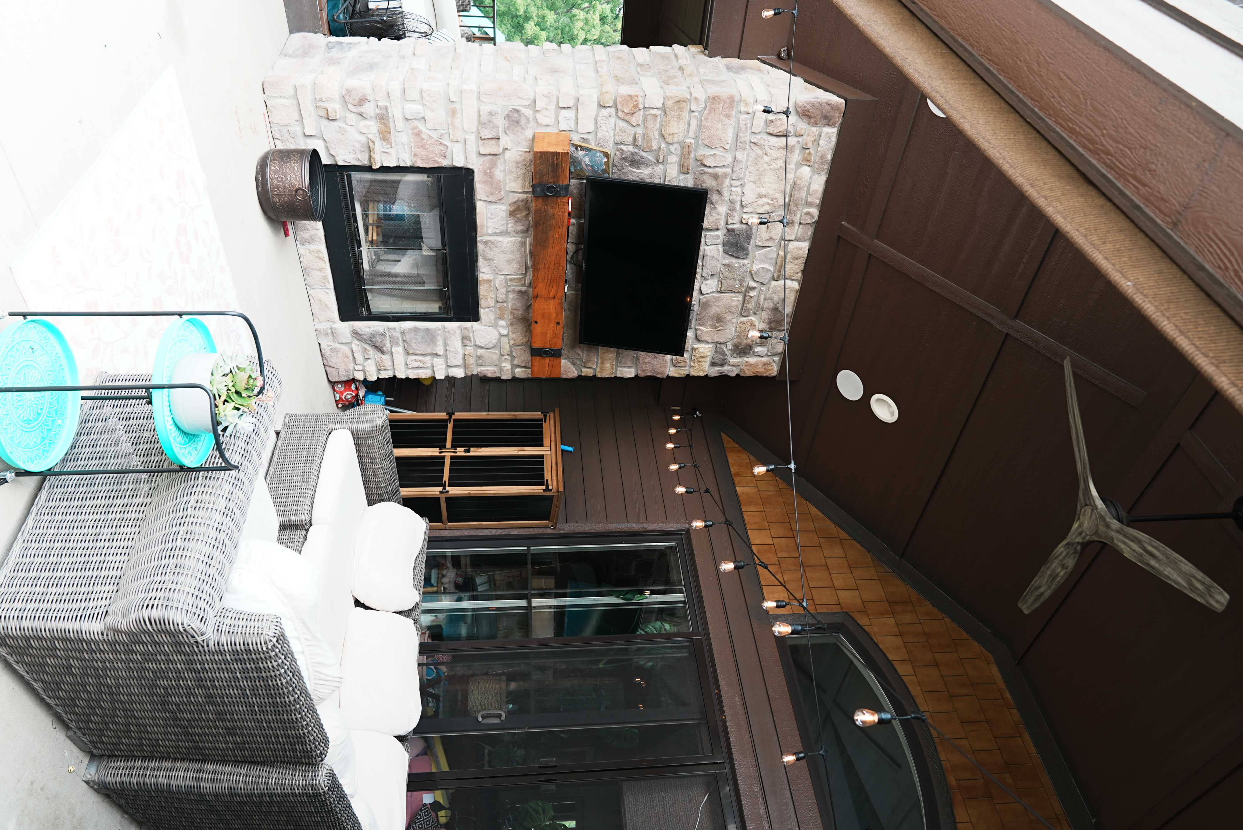 Covered outdoor living space with stone fireplace
