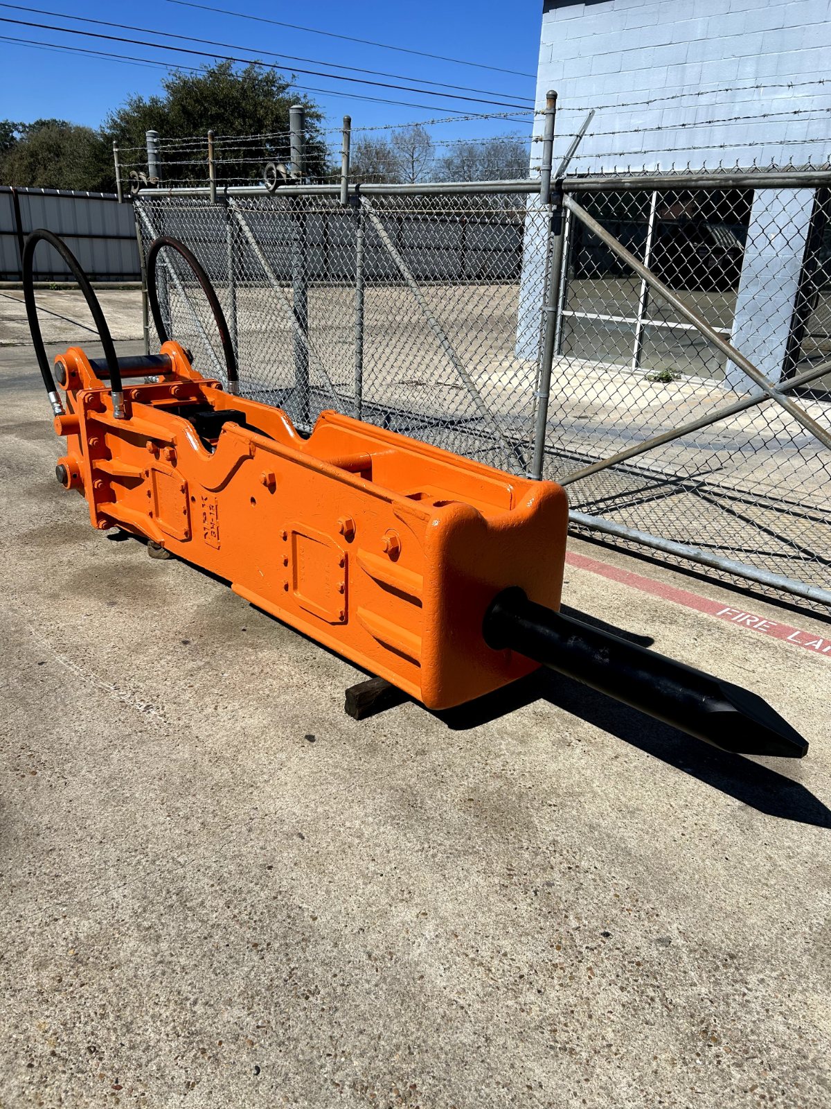 Rebuilt orange hydraulic hammer with a new tool