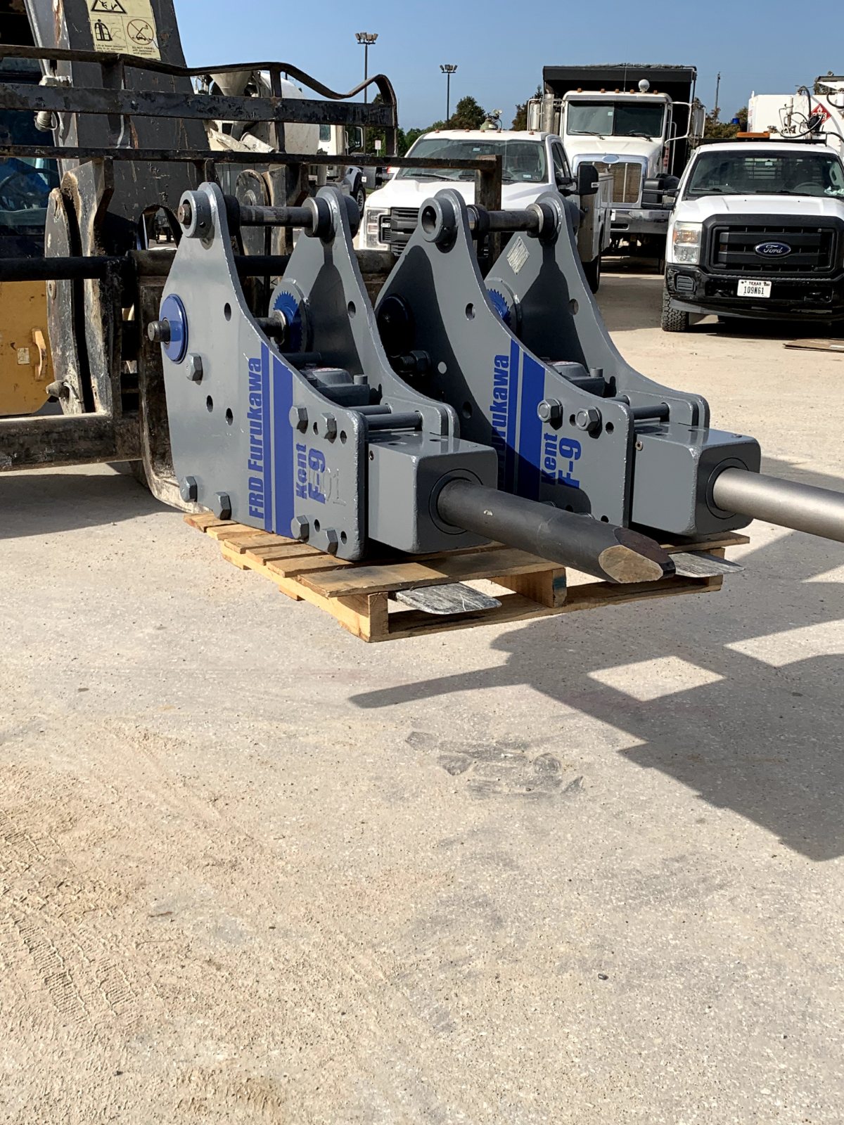 Row of serviced hydraulic hammers on a pallet