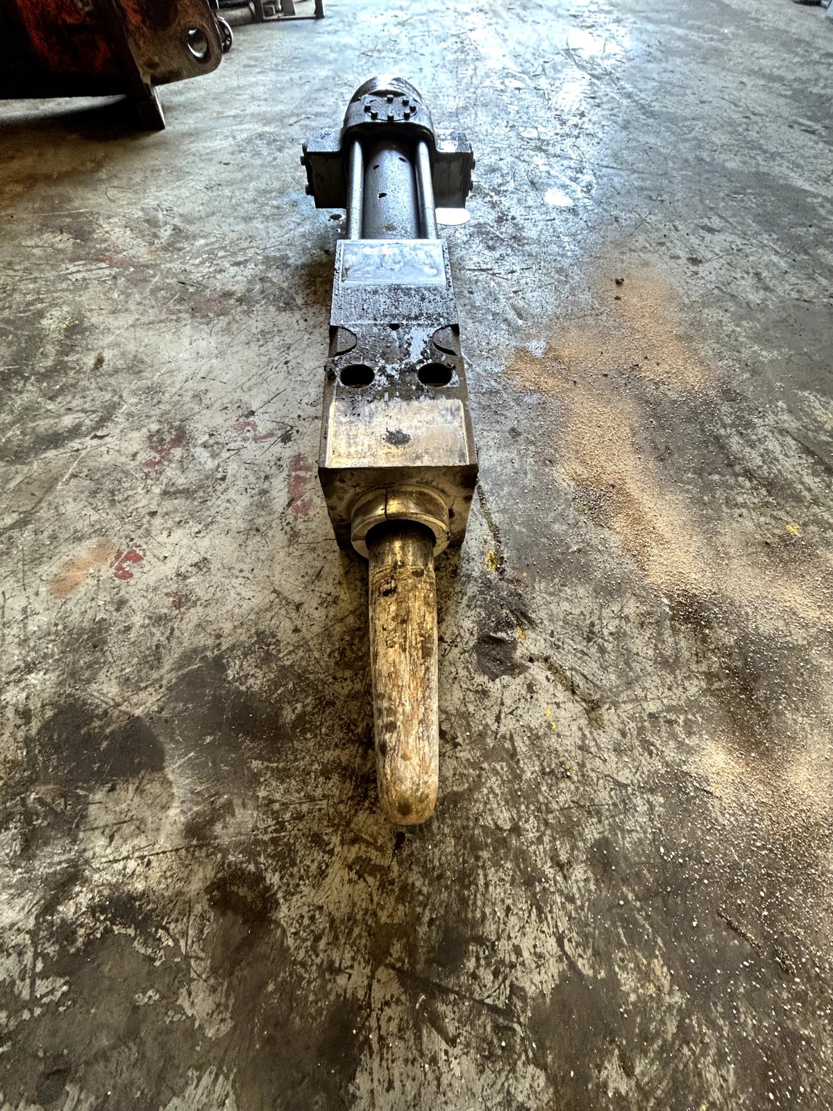 Worn hydraulic hammer on the shop floor before service