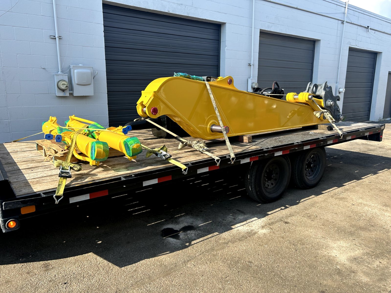 Repaired hydraulic equipment strapped to a flatbed trailer