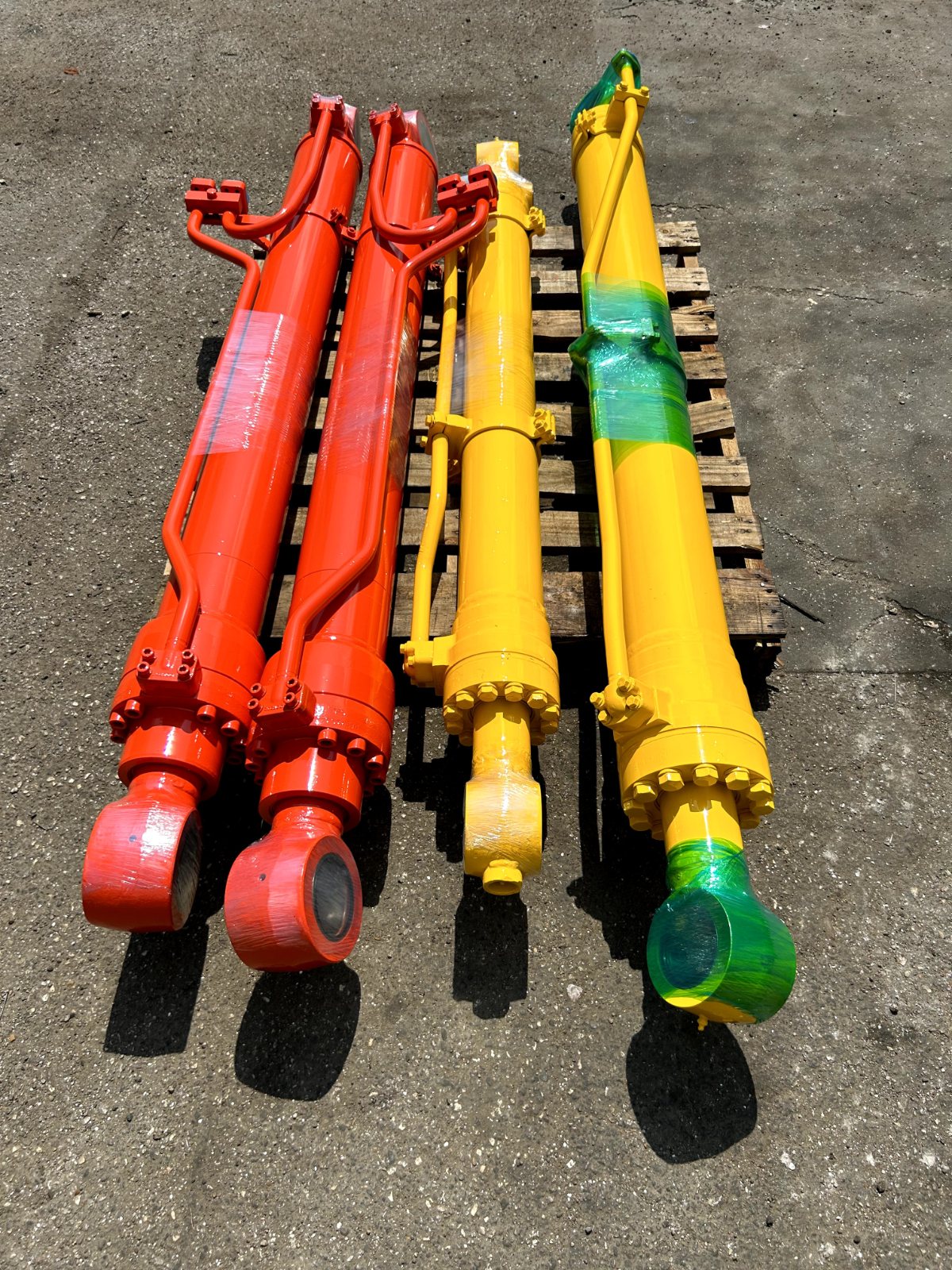 Four repaired hydraulic cylinders on a pallet