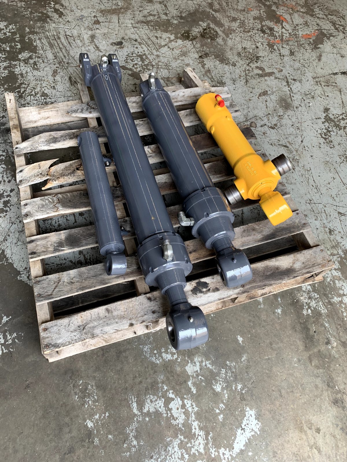 Repainted small hydraulic cylinders on a pallet