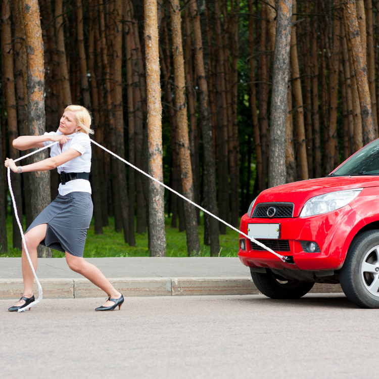 Woman pulling a car on a rope