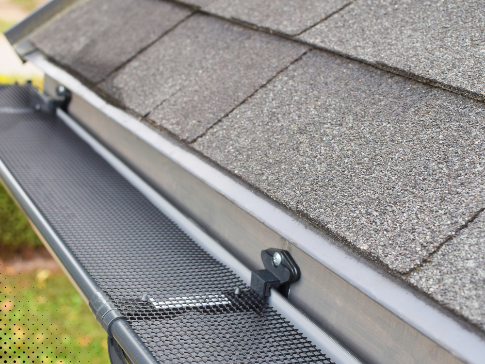 Close-up of a roof gutter with a mesh guard to prevent debris buildup, ensuring proper drainage.