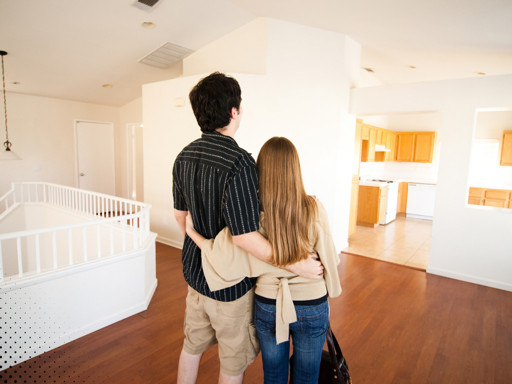 Couple admiring the interior of their new home with a sense of excitement and possibility.