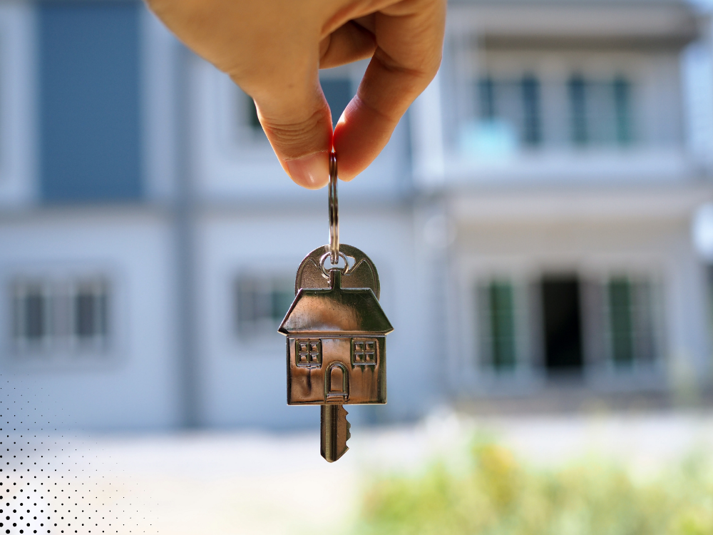 House key held in front of a new home for buyers scheduling a Fort Worth TX home inspection