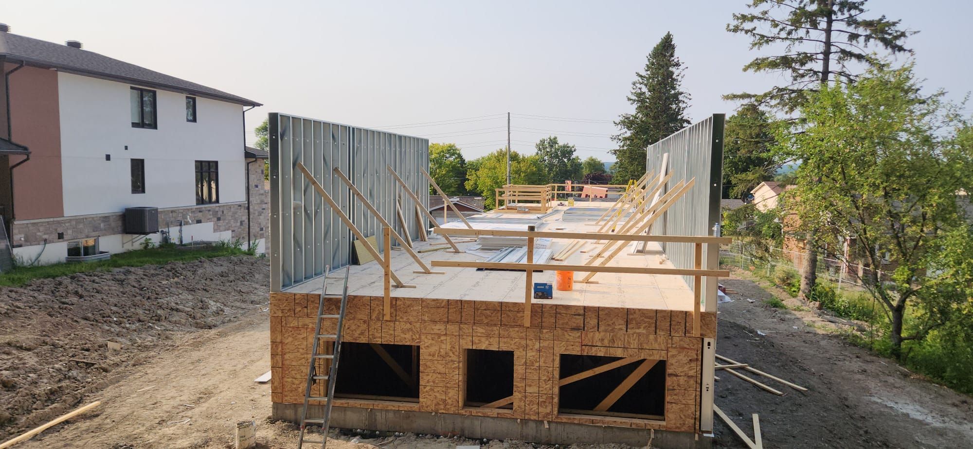 Steel stud walls on wood podium, hybrid steel and wood framing