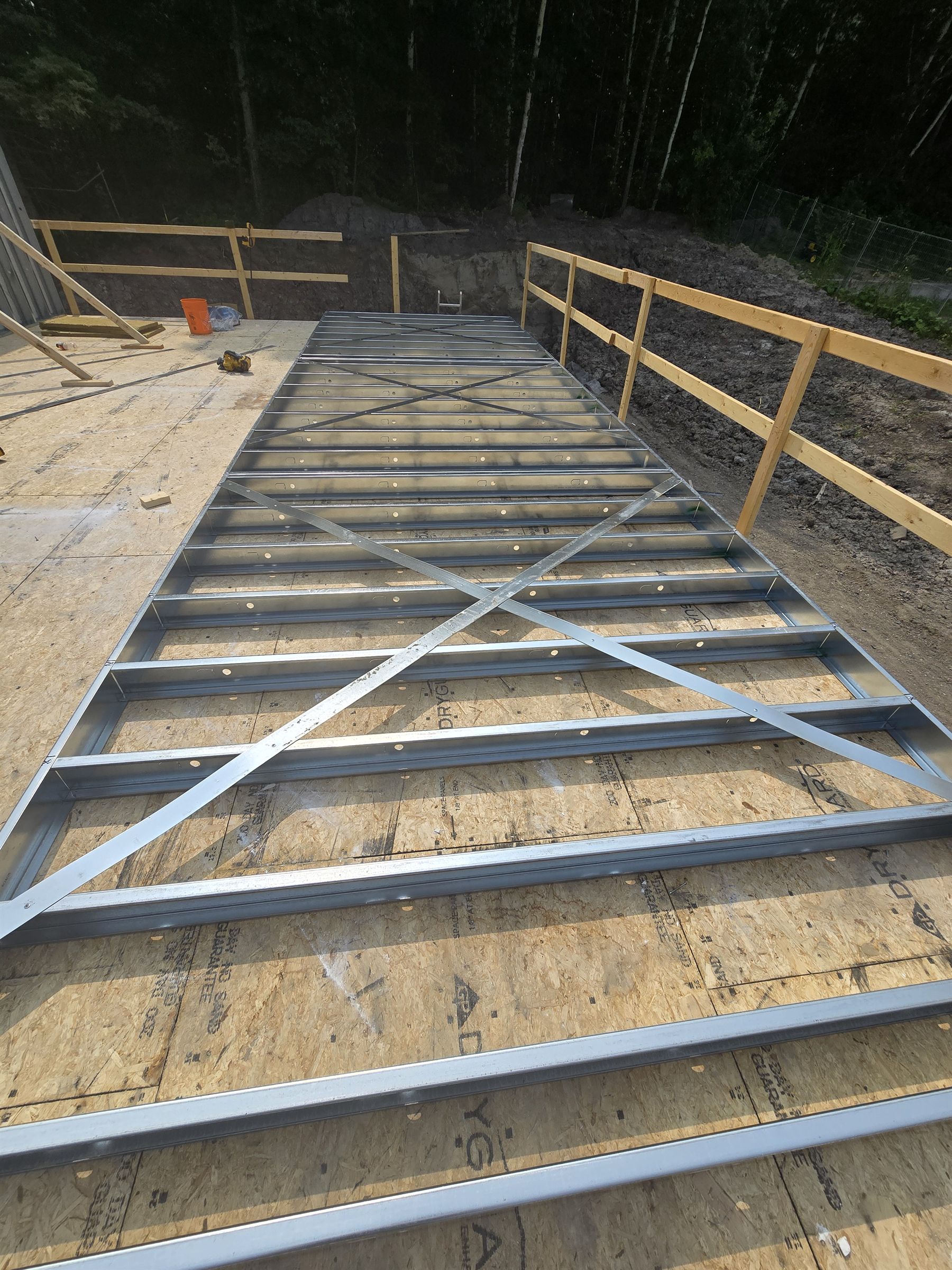 Steel floor joist panel on wood subfloor, hybrid steel and wood framing