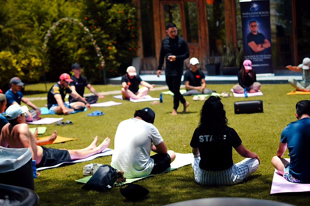 Grupo practicando sobre tapetes al aire libre durante una experiencia de NOVA Conciencia