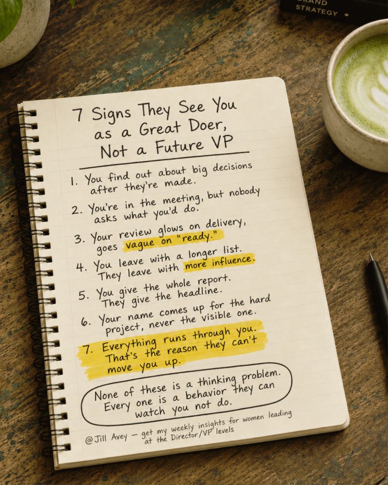 An open spiral notebook resting on a wooden table next to a cup of green tea, featuring handwritten text titled "7 Signs They See You as a Great Doer, Not a Future VP." The list details seven career behaviors: finding out about decisions late, being in meetings without being asked for input, glowing delivery reviews that lack readiness, leaving with a longer list while others gain influence, giving the whole report while others give headlines, getting assigned hard projects instead of visible ones, and being the bottleneck through which everything runs. A concluding note reads: "None of these is a thinking problem. Every one is a behavior they can watch you not do."