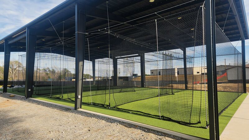 Outdoor batting cage beside a school baseball field in Texas