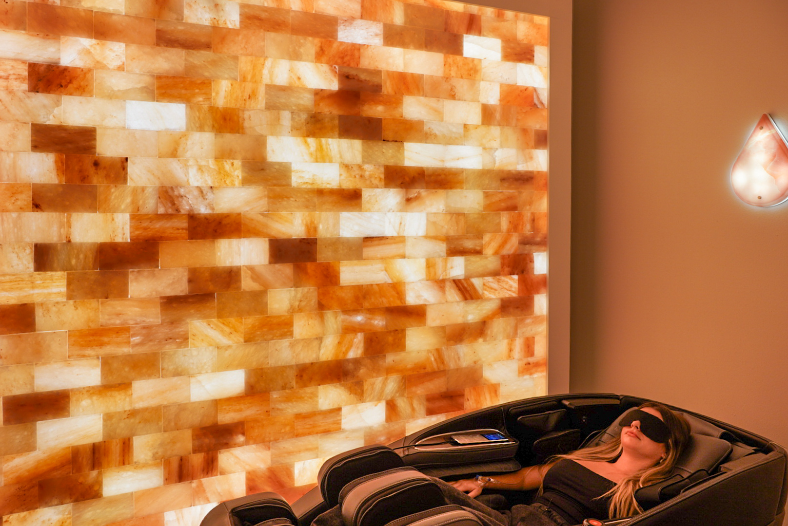 Relaxing in a massage chair beside the illuminated salt wall at Prime IV Niceville