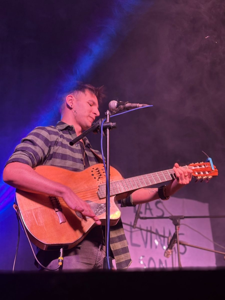 Natanael Oviedo tocando la guitarra en el escenario de un festival