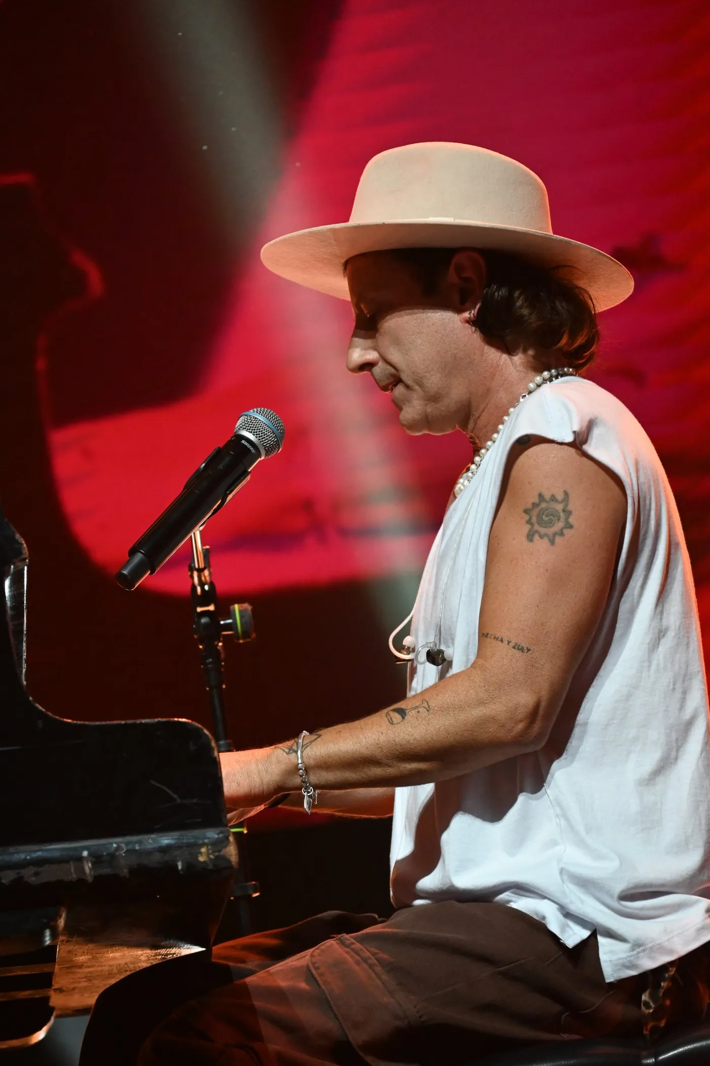 Coti al piano, con sombrero, de perfil