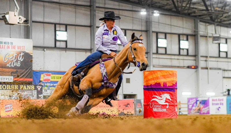 Kathy Grimes running barrels on a Burns saddle
