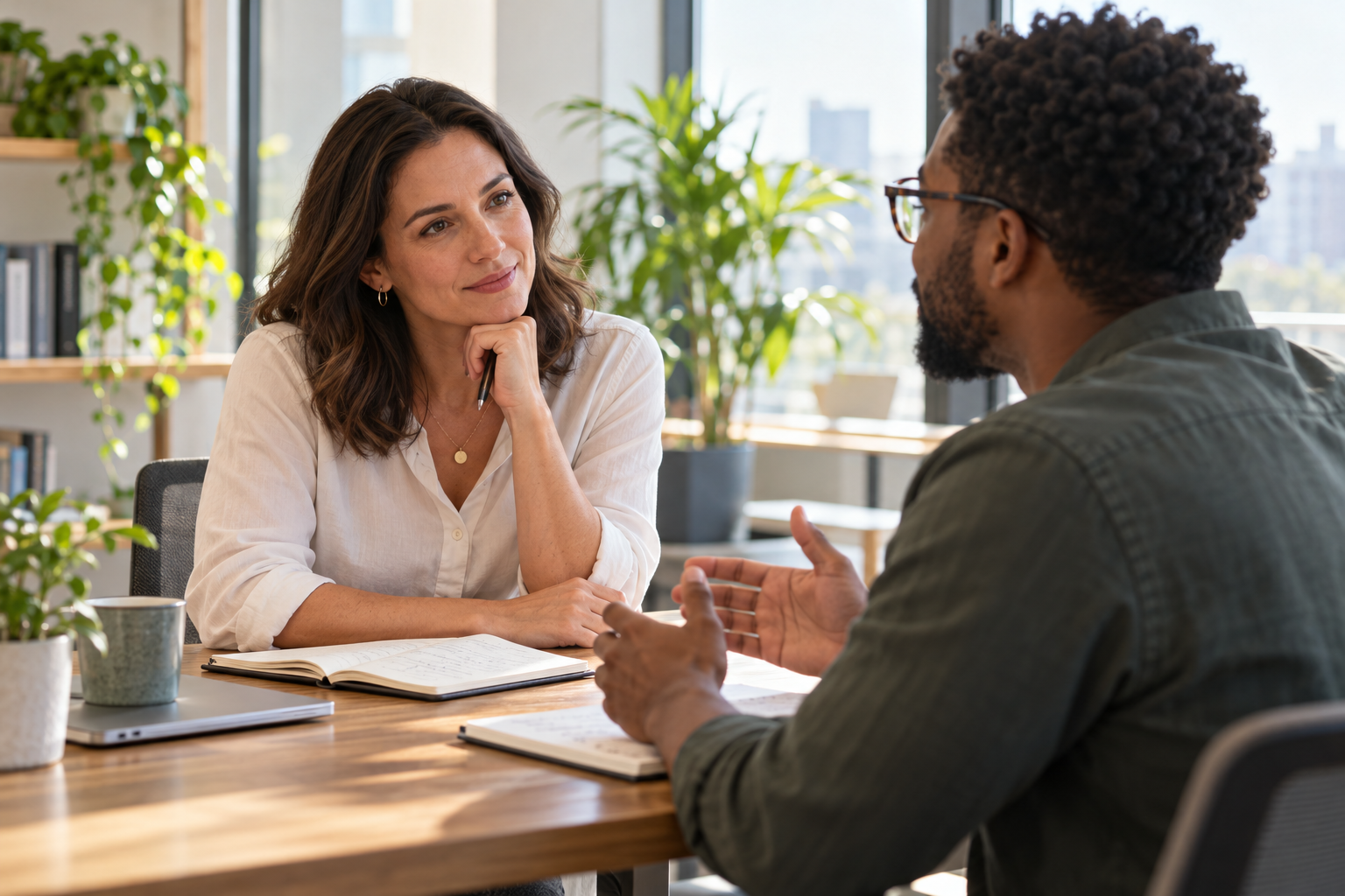 Woman leader listening attentively to a colleague during a one-to-one conversation Woman leader listening attentively to a colleague during a one-to-one conversation