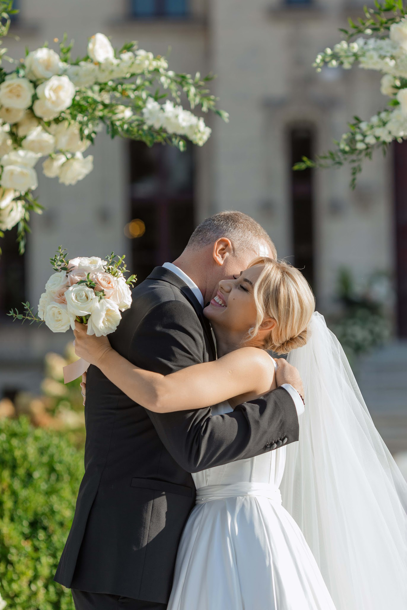 Bride and groom embracing after their outdoor wedding ceremony at Château Challain in Challain-La-Potherie, Pays de la Loire, France Bride and groom embracing after their outdoor wedding ceremony at Château Challain in Challain-La-Potherie, Pays de la Loire, France