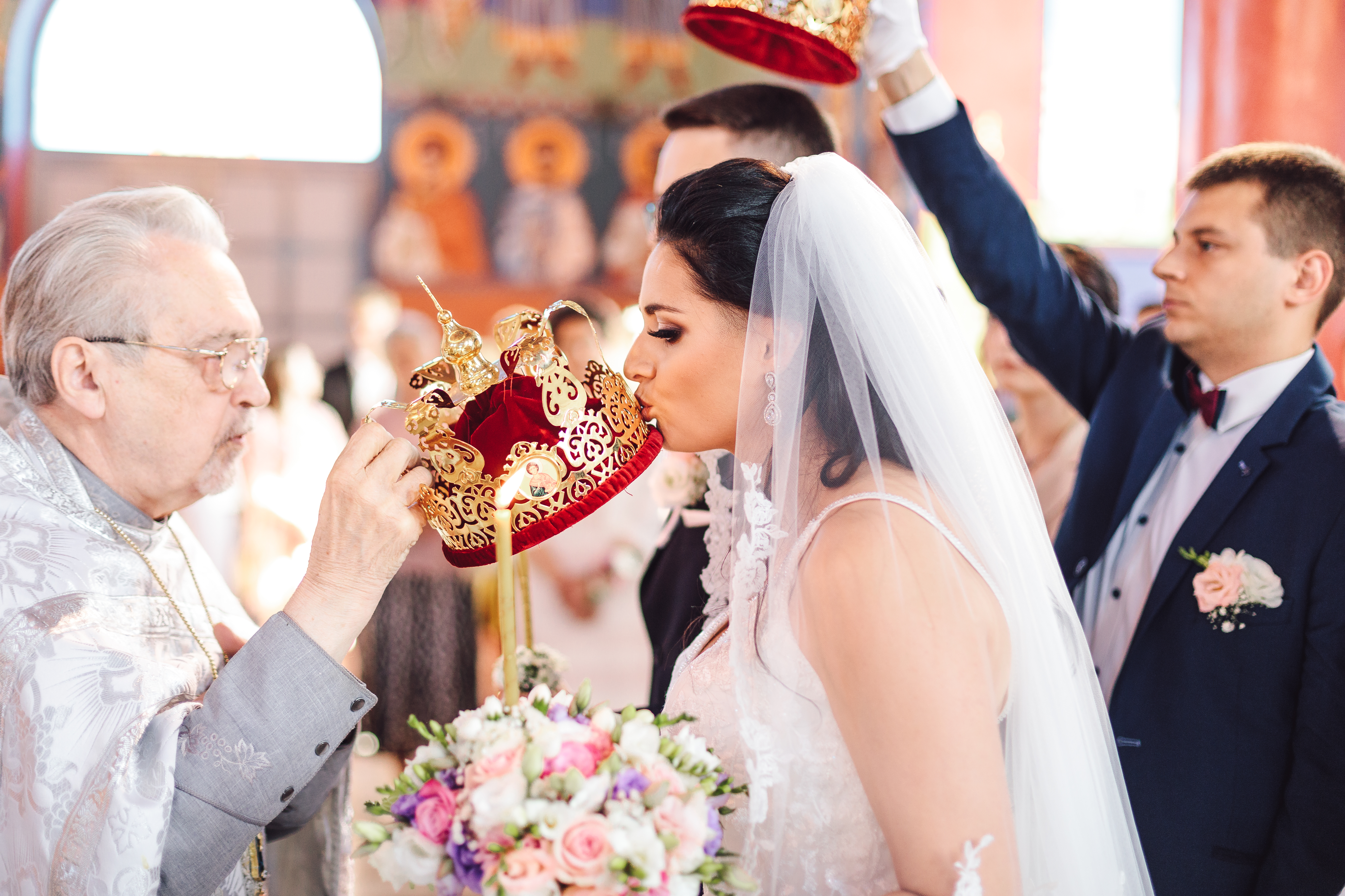 Bride kissing a ceremonial crown during a church wedding in Warsaw, photographed by Lubov Lisitsa
