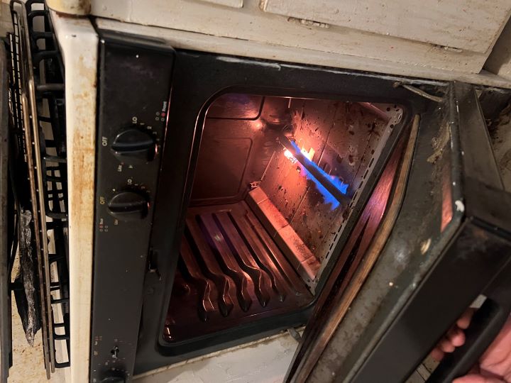Gas oven burner with flame during professional oven repair by Sammy Appliance Repair in NYC