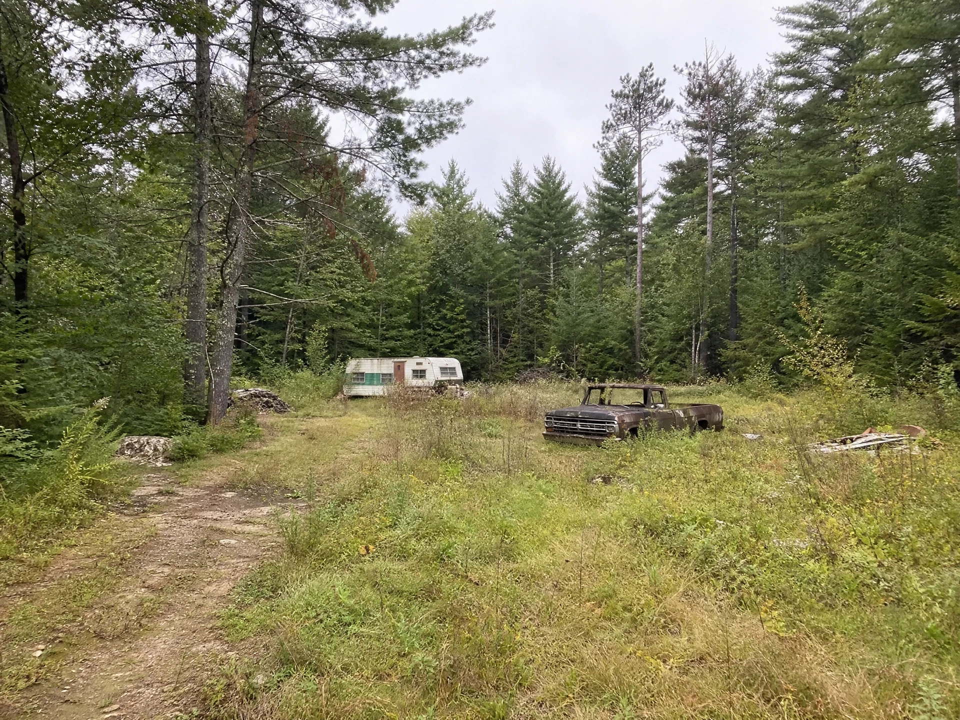 Overgrown wooded land parcel with an abandoned camper in Windham, Maine