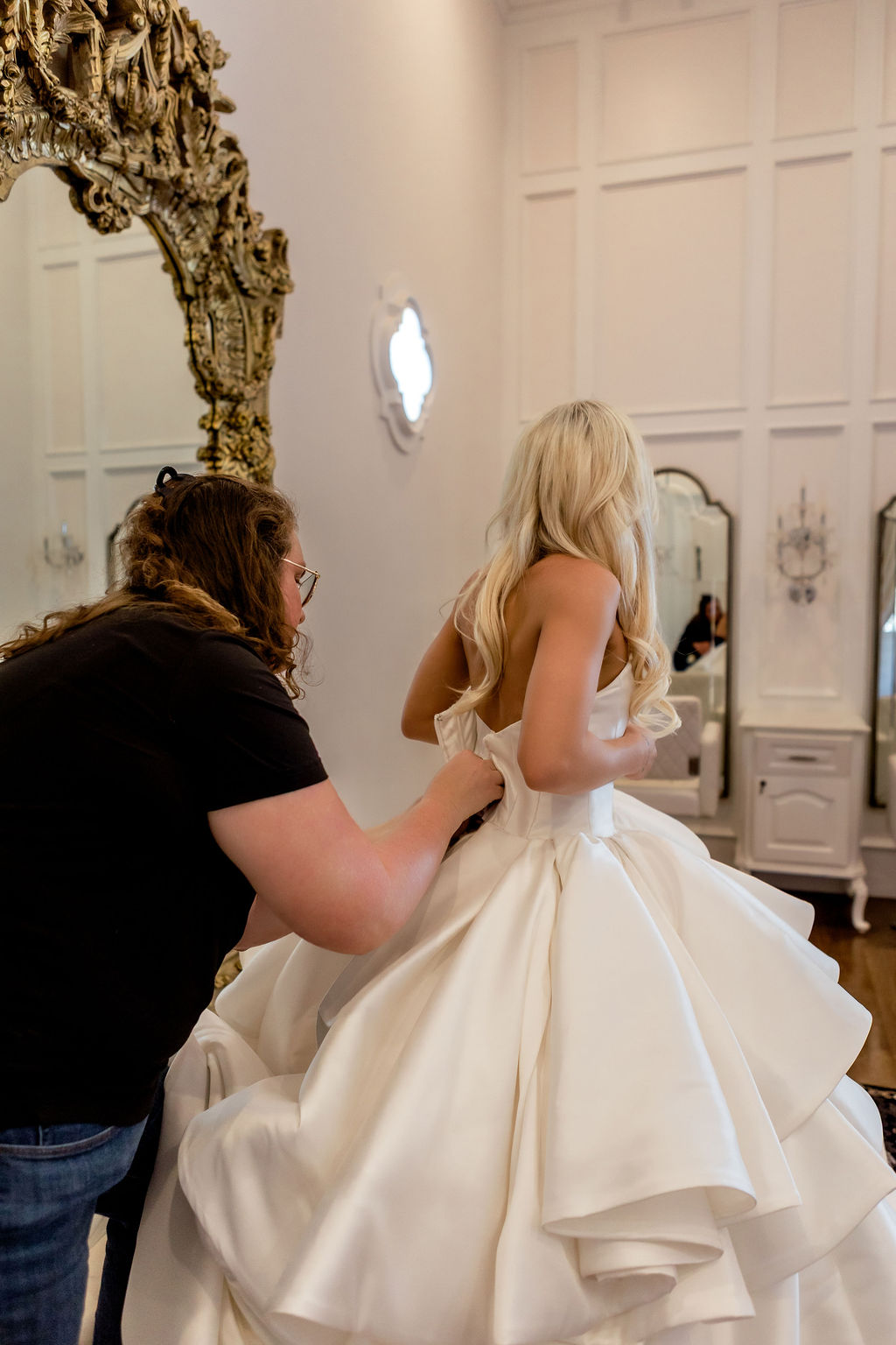 Zipping the back of a wedding gown before the ceremony