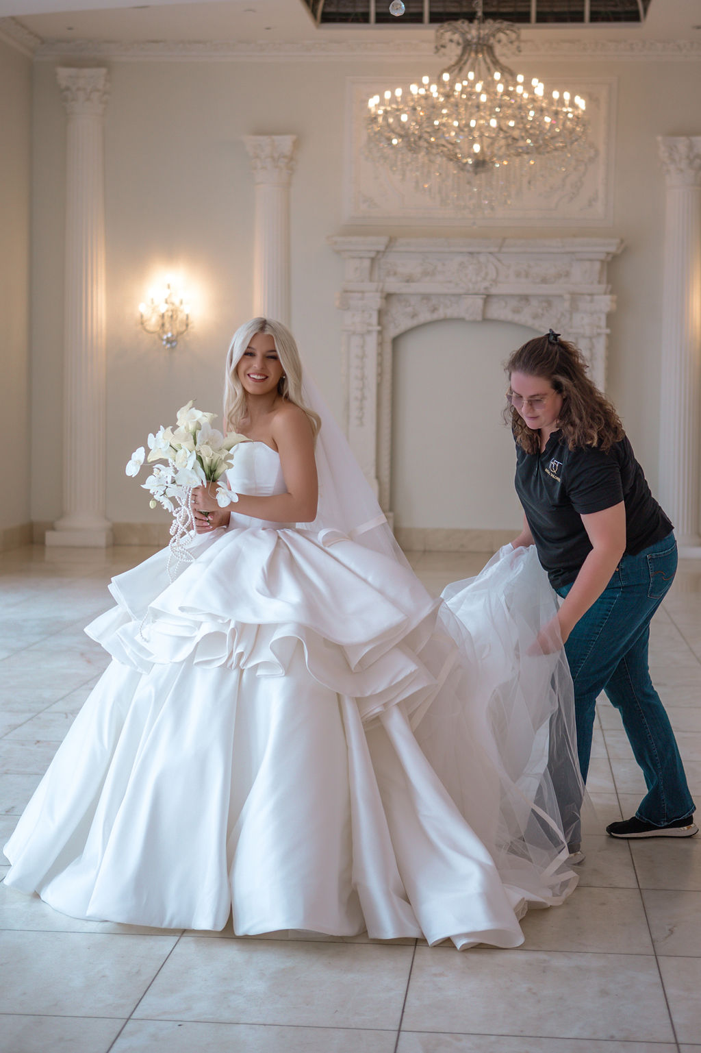 Fluffing the train of a wedding gown for photos