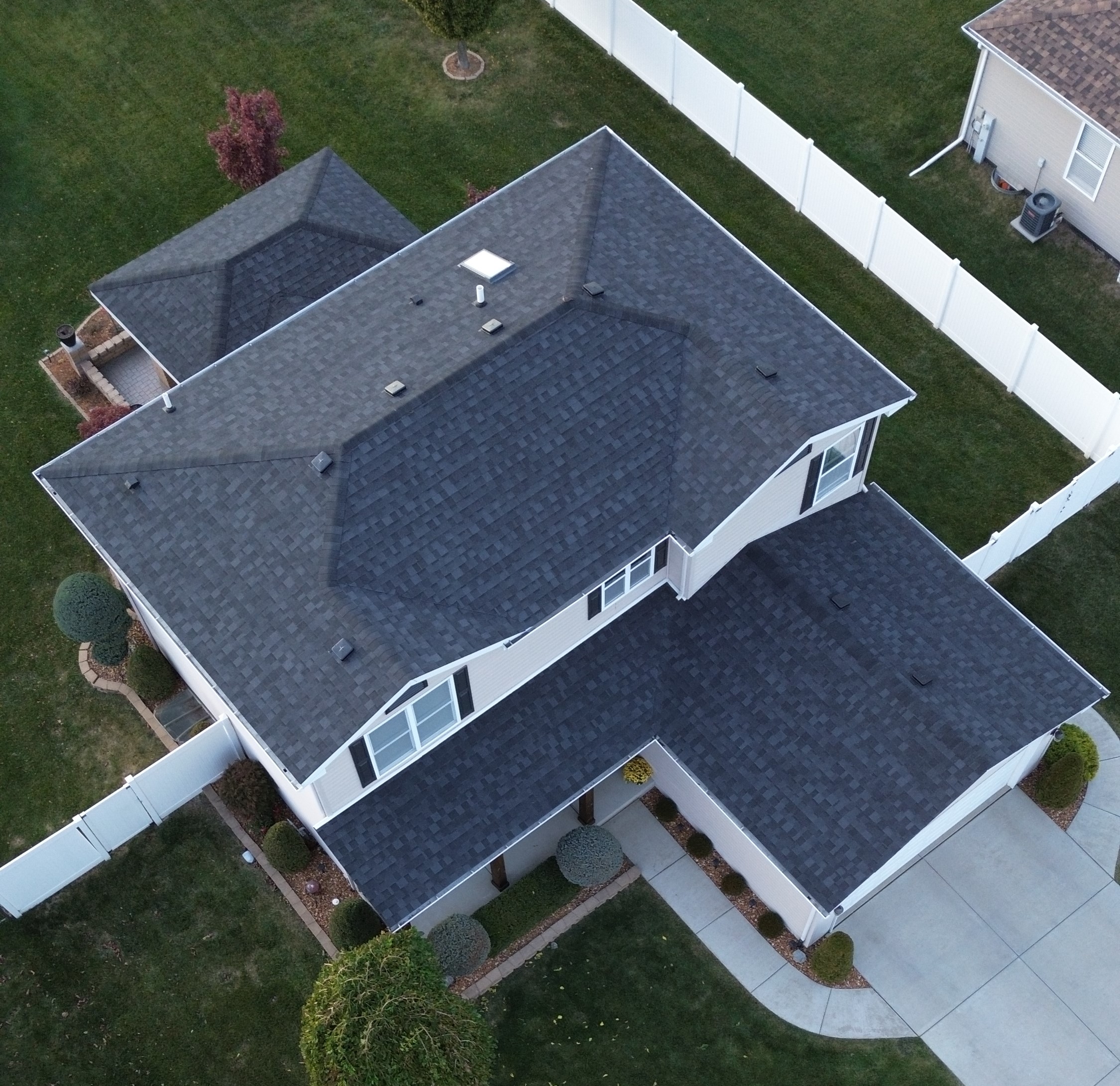 Aerial view of emergency roof repair in progress on a residential home in Manteno Illinois with roofing crew addressing storm related damage