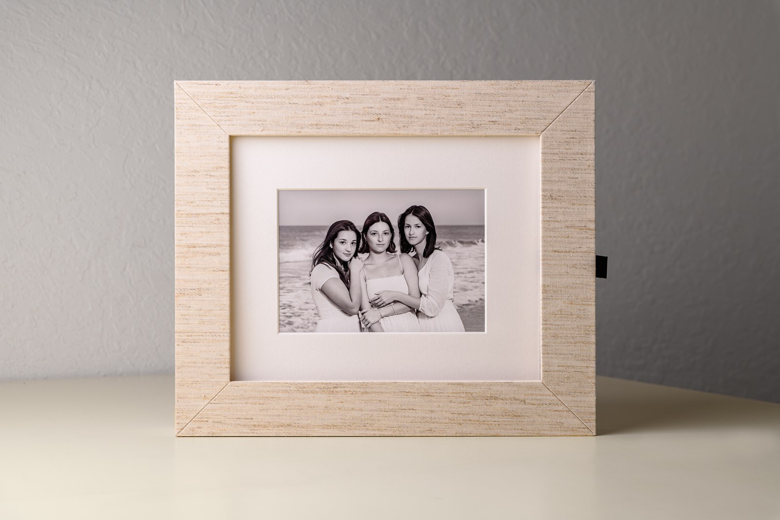 Linen folio with dramatic backdrop — framed beach portrait on display