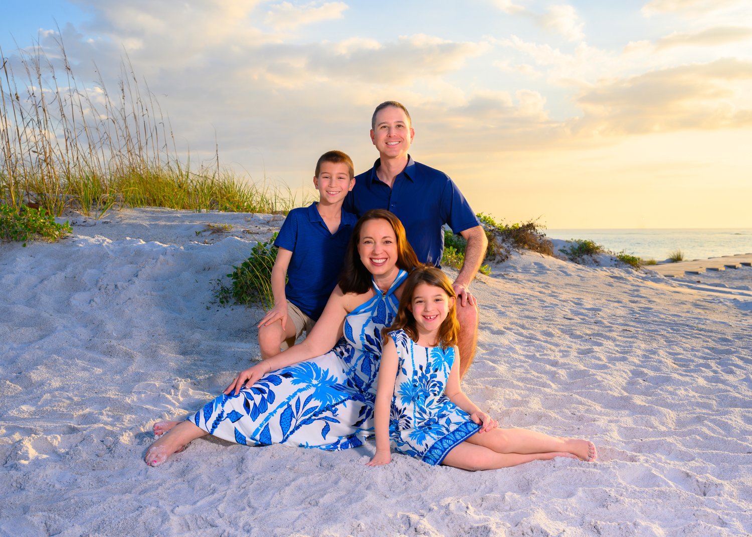 Family with young children in the beach dunes at sunset