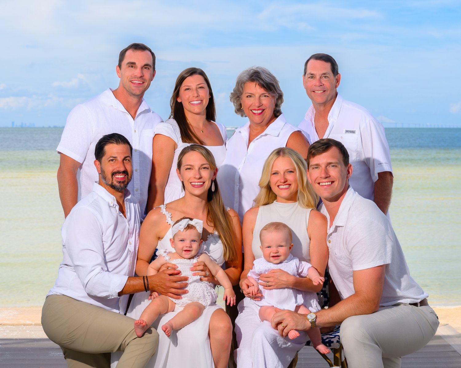 Multigenerational family with babies on a dock over turquoise Gulf water