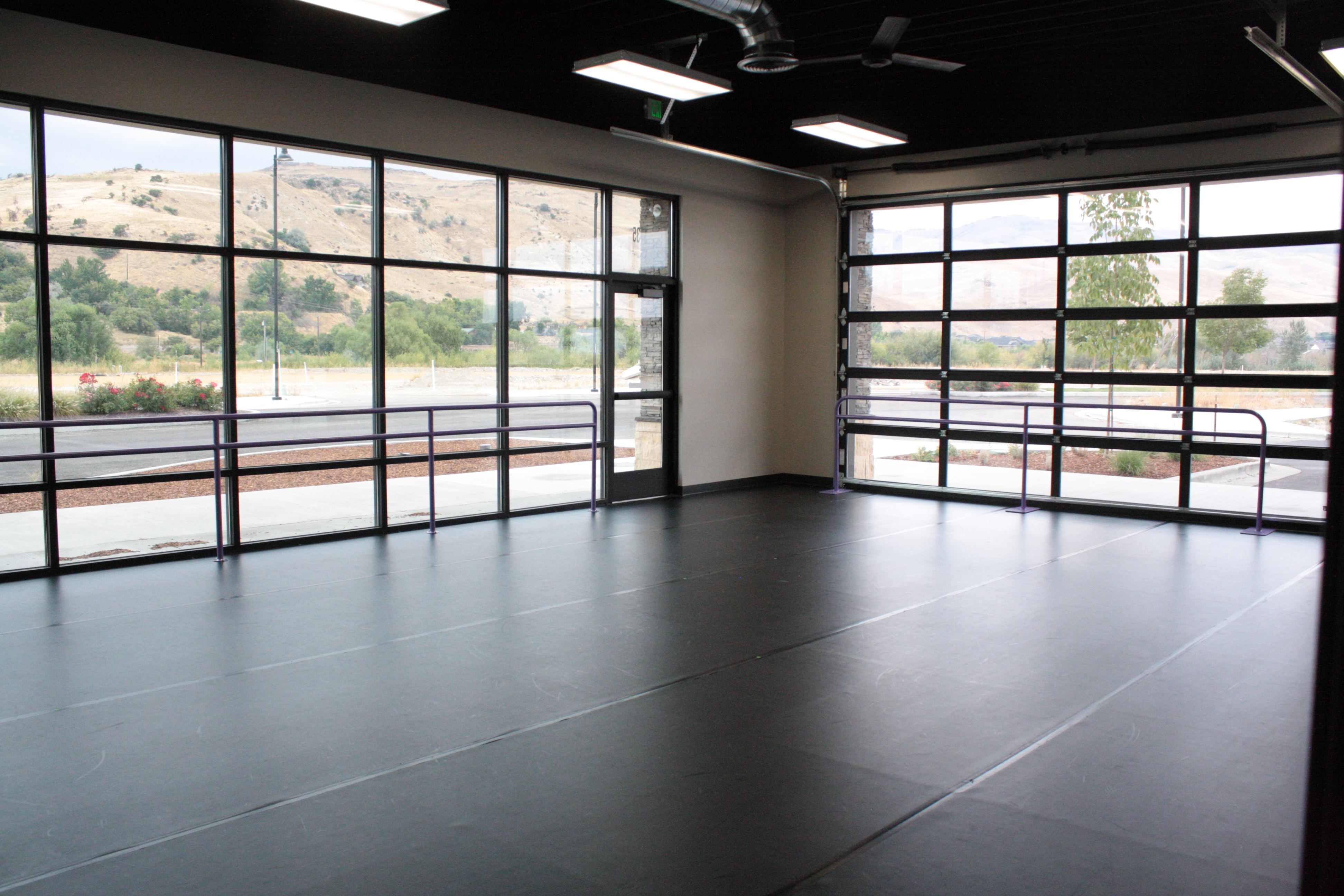 large dance studio with tall glass windows for natural light and ballet barres