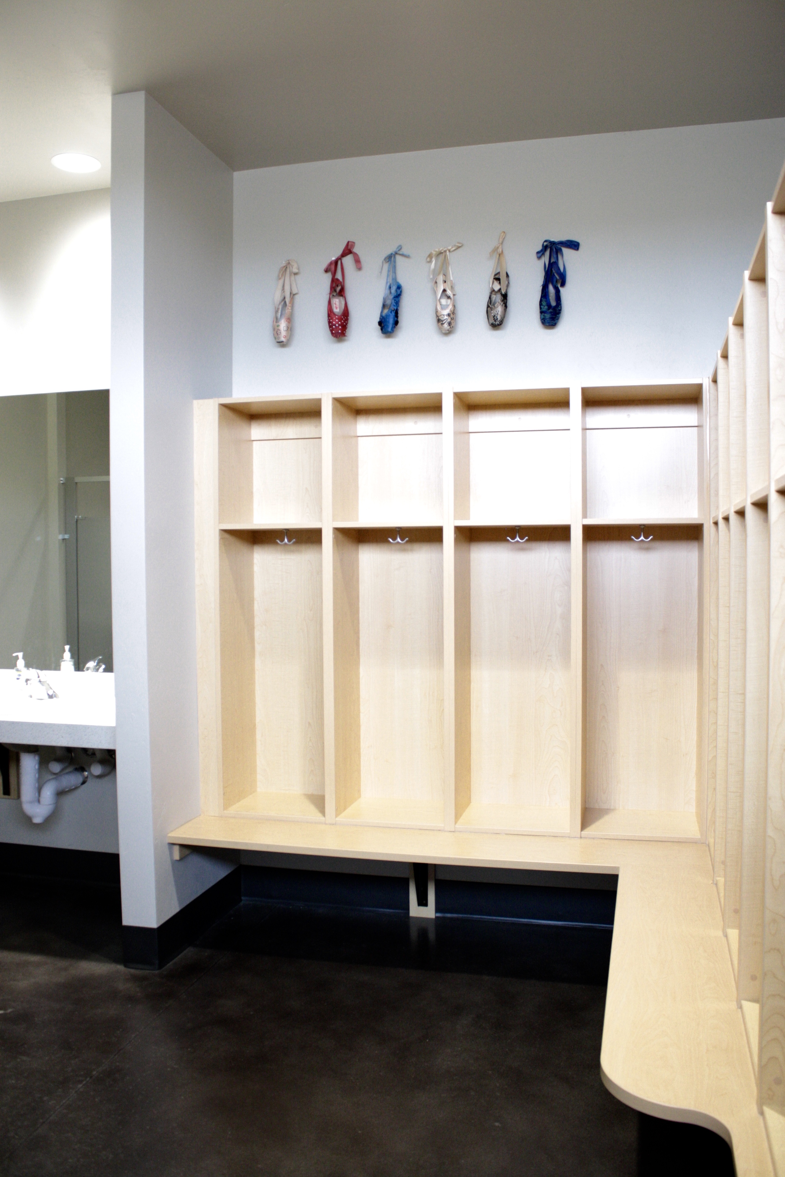 locker room with cubbies, sinks, pointe shoes on wall