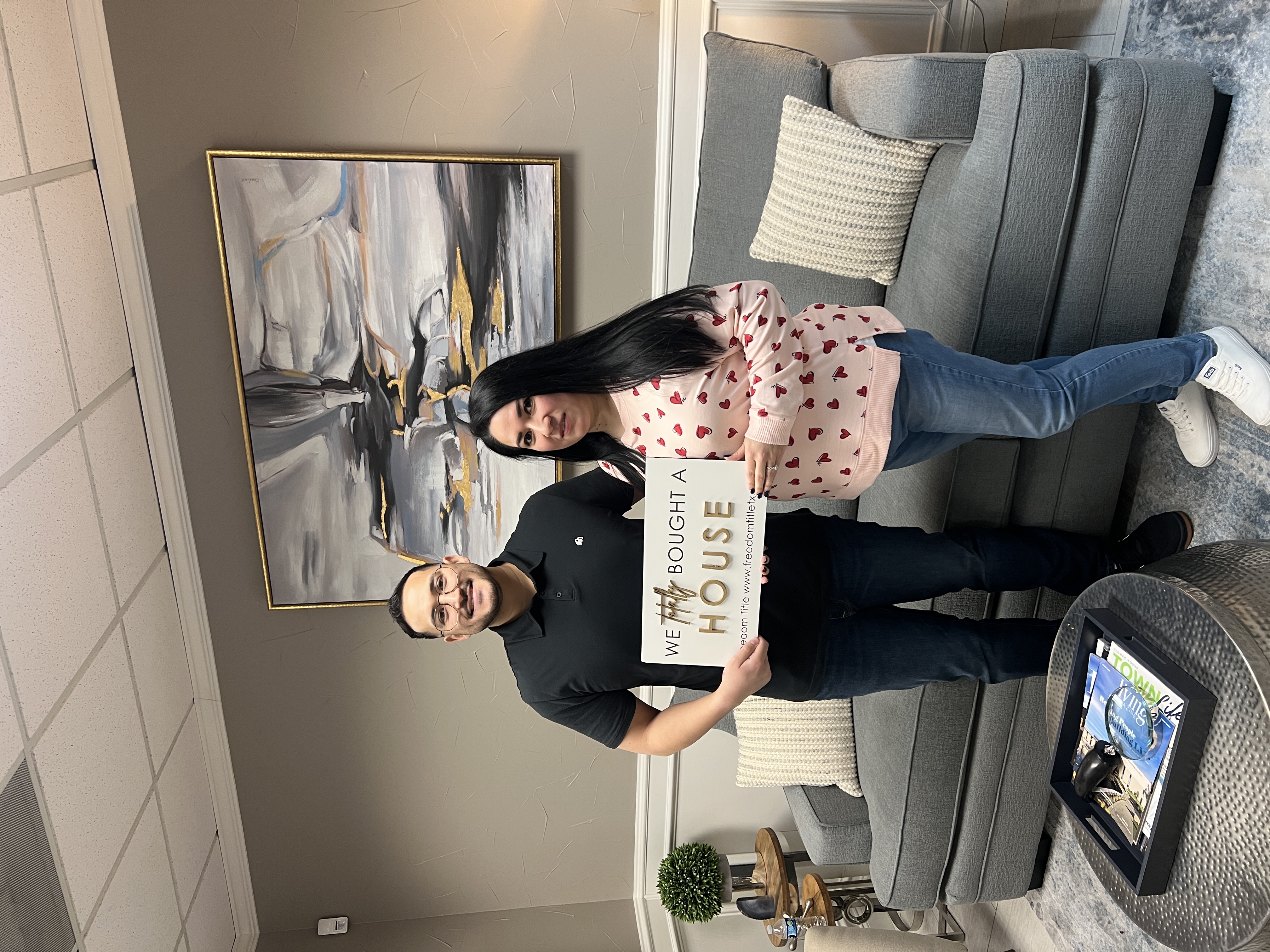 DFW homebuyers at closing holding their new-home sign with real estate agent Zacc Mitchell