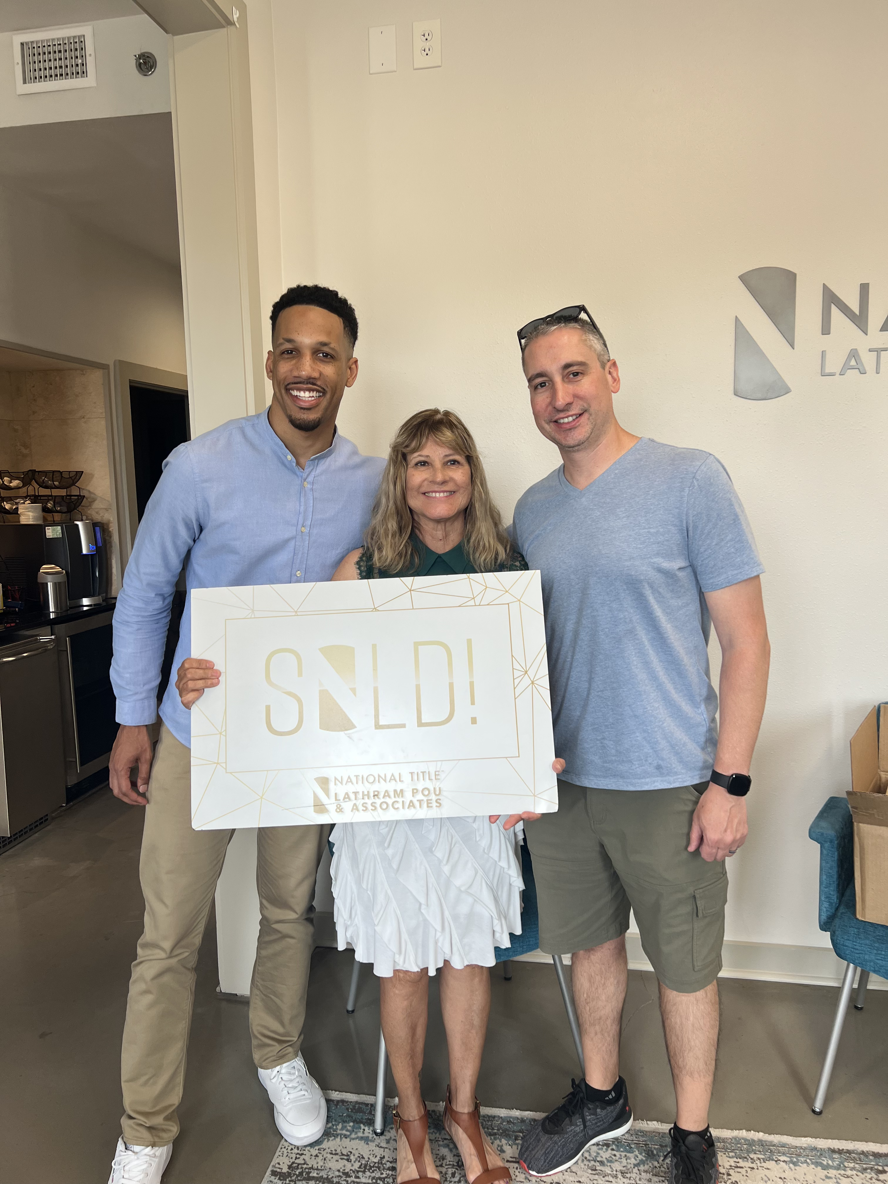DFW homebuyer holding keys and smiling at closing with Zacc Mitchell