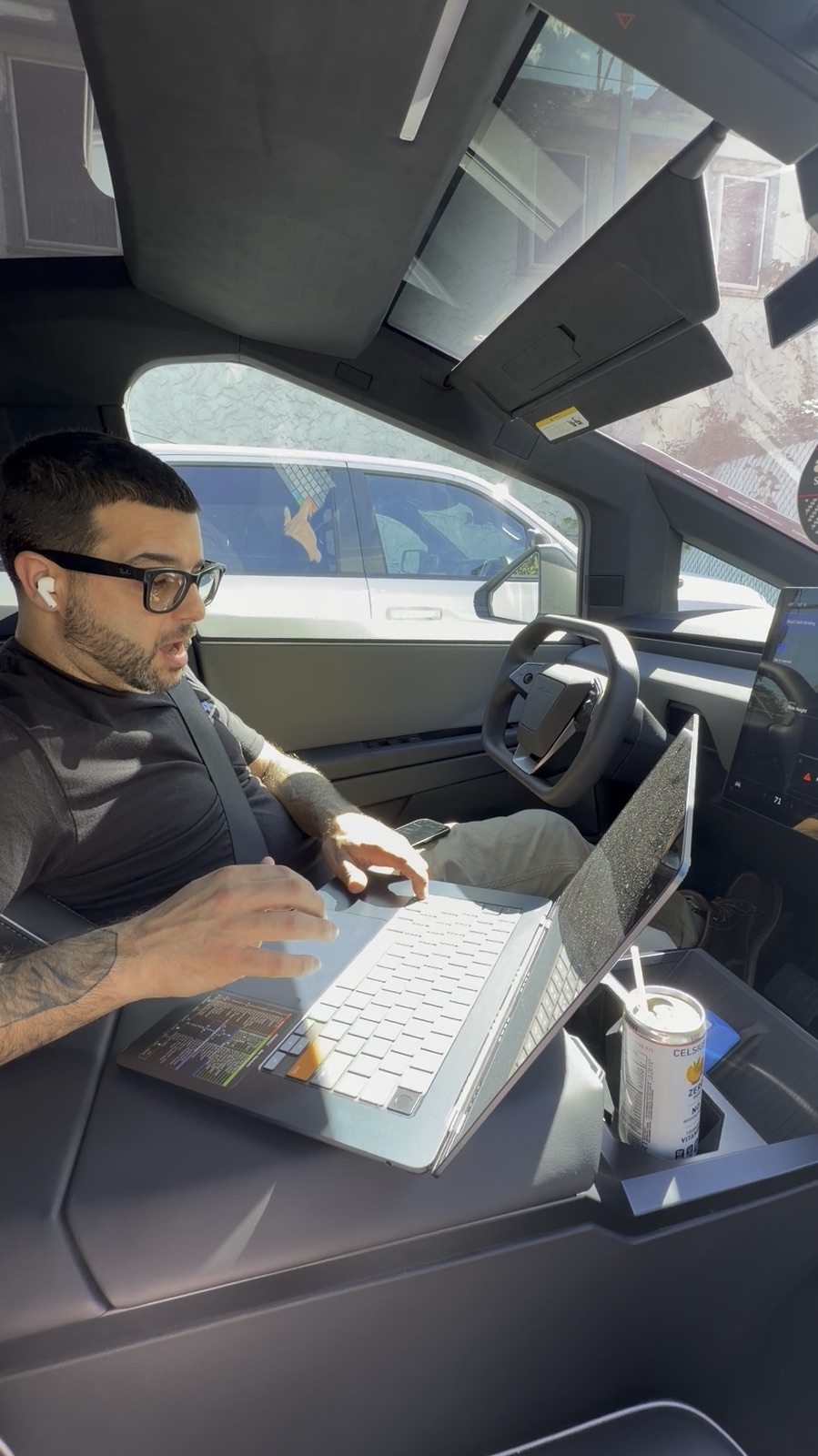 Scott Bruni working on a laptop from the driver's seat of his truck