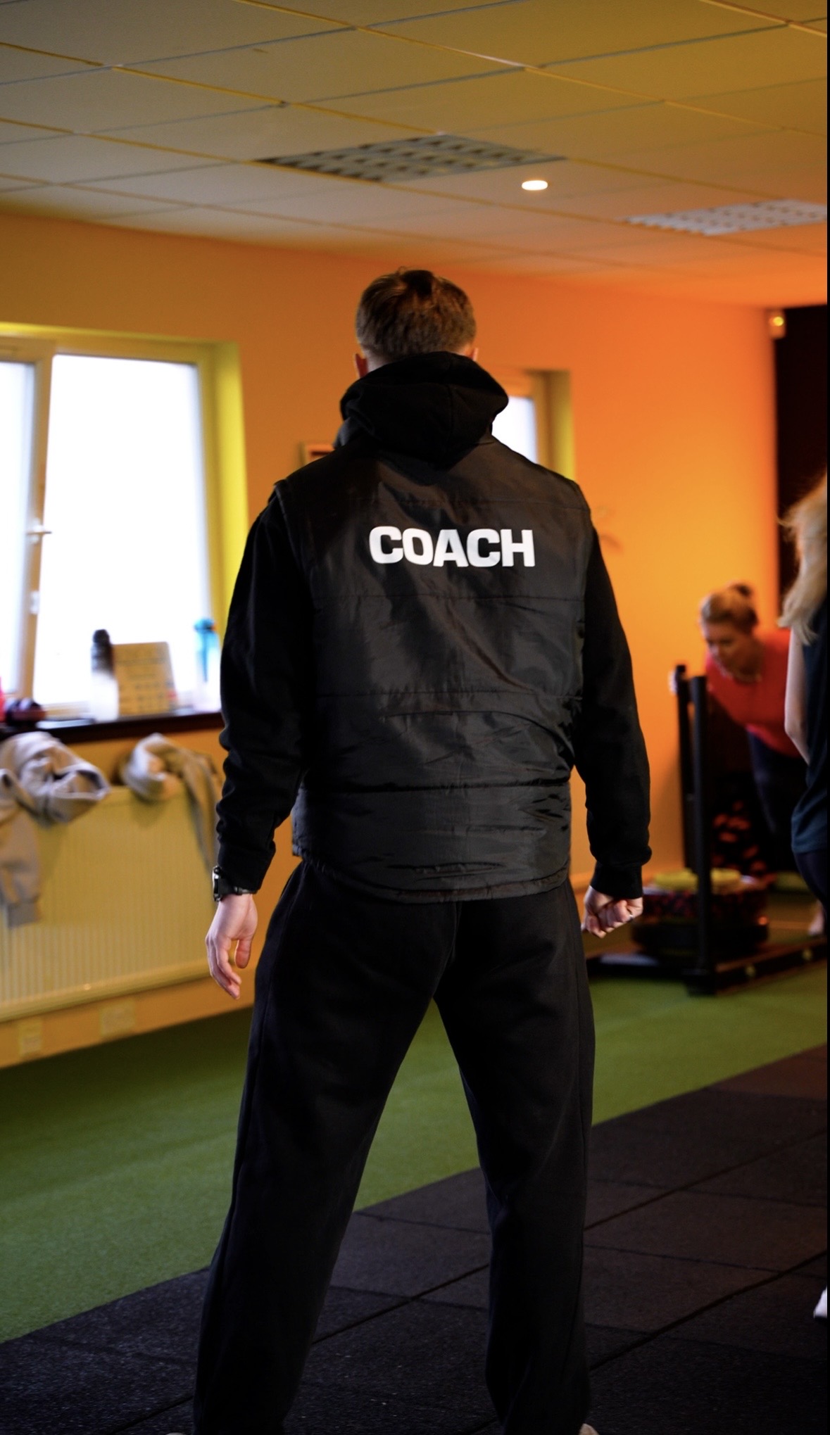 A Neon coach supporting a session in the gym