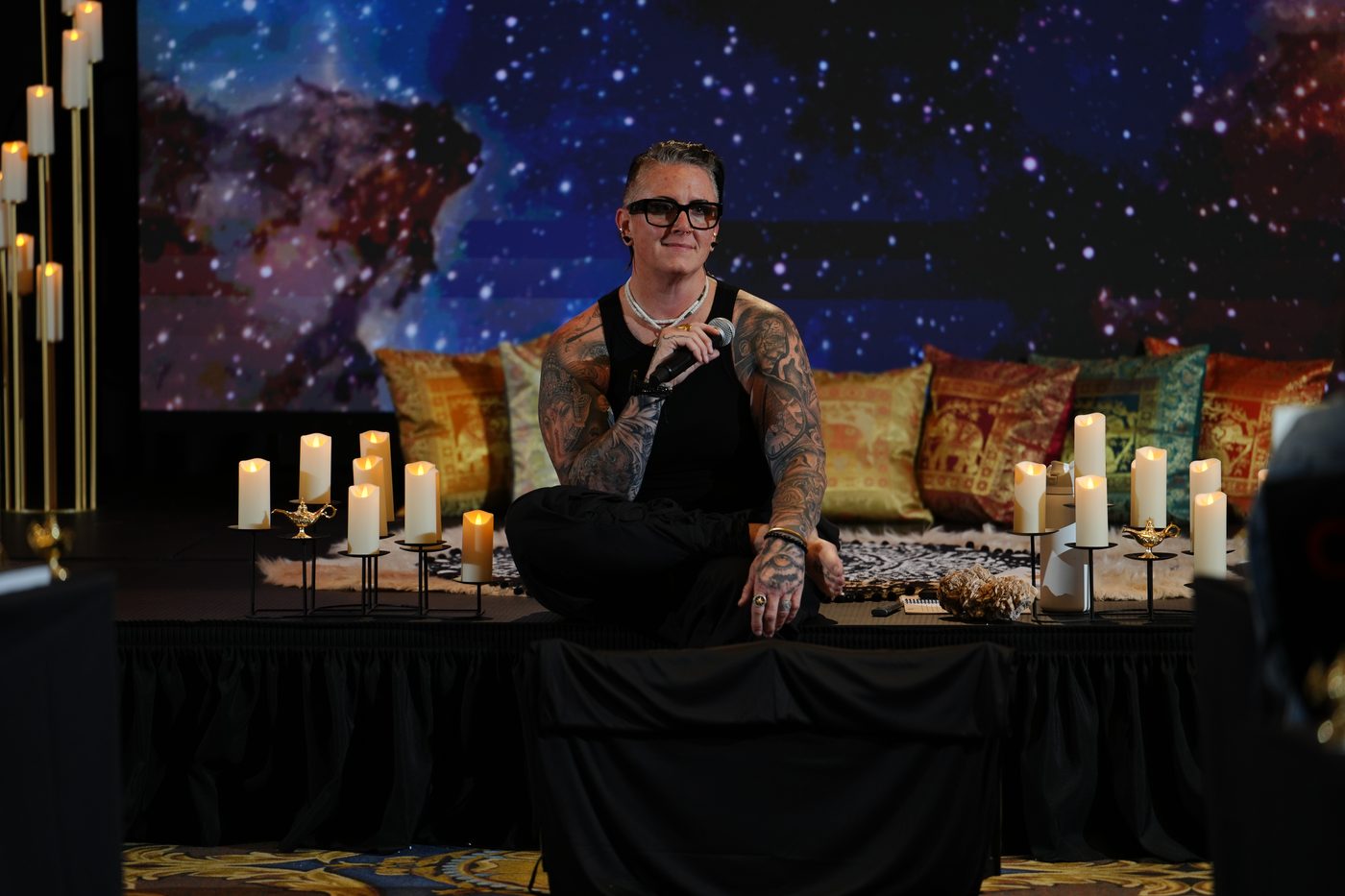 Jen Conkey seated on a lounge stage set with a microphone