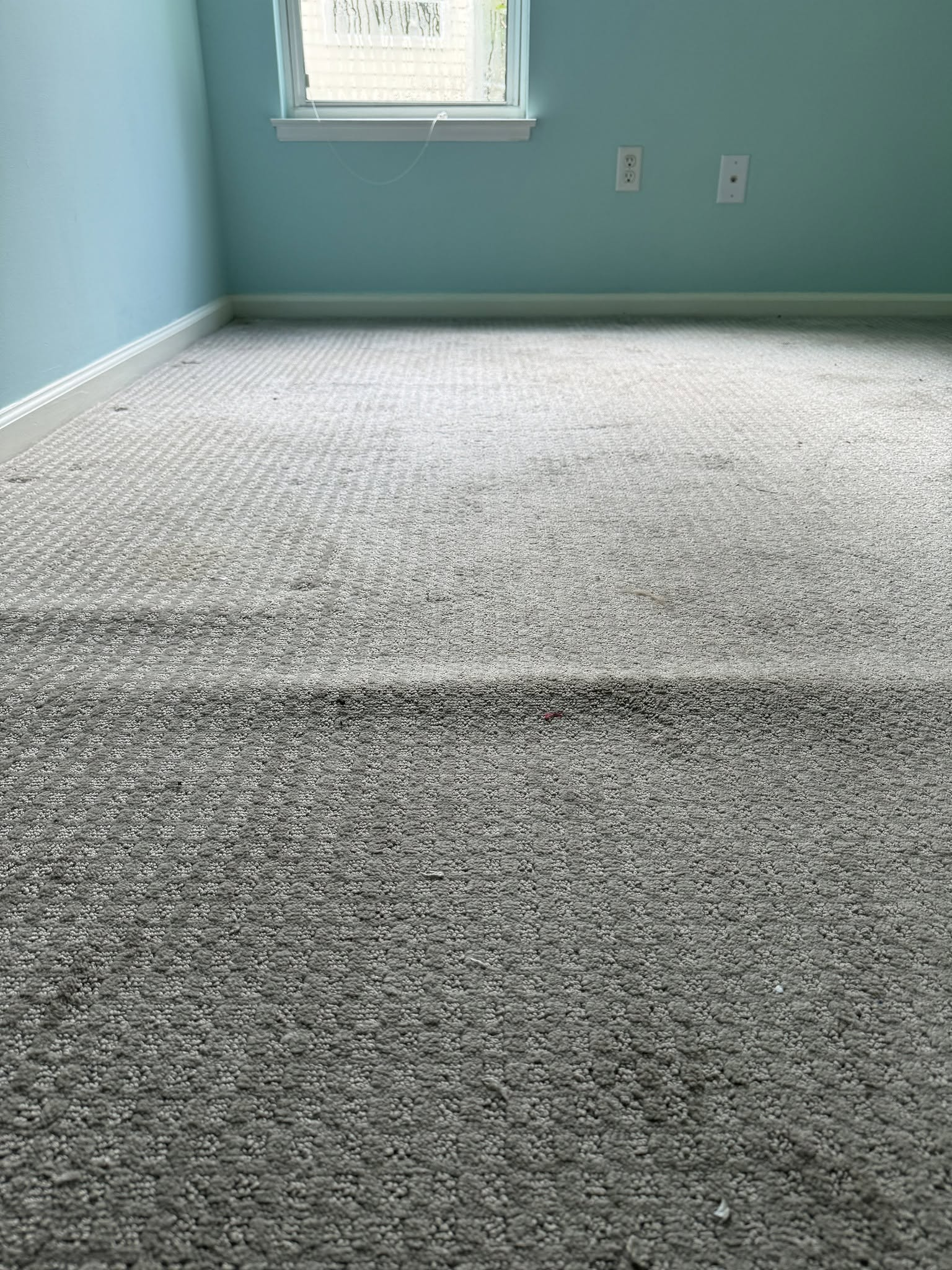 Carpet with visible ripples across the surface before restretching.