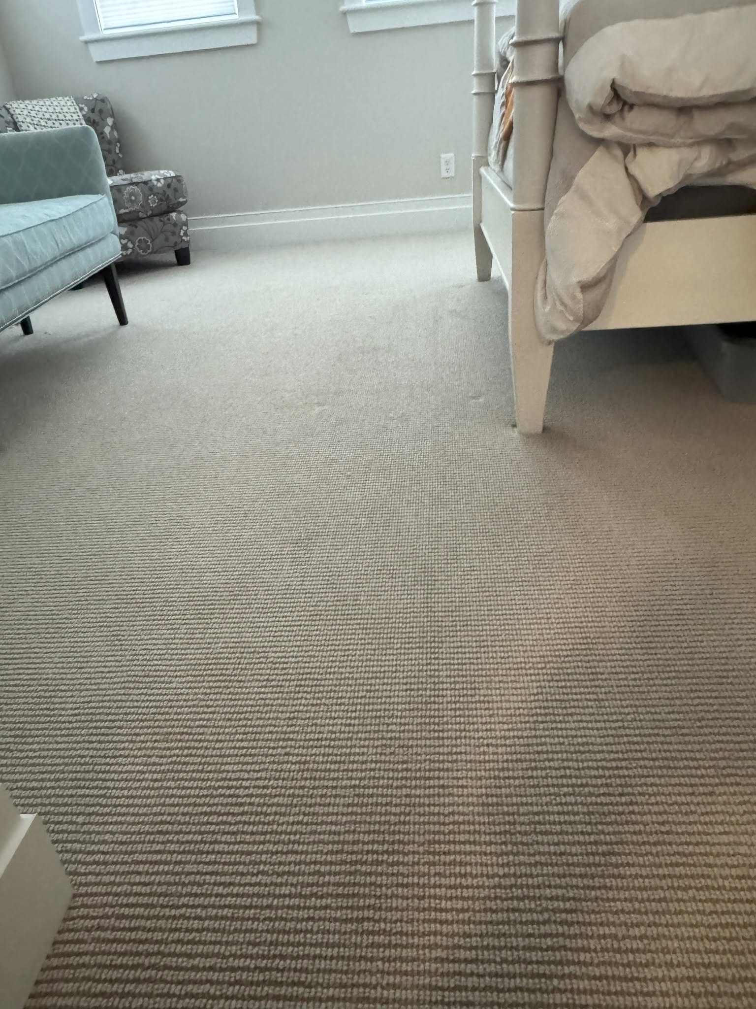 Room 1 after restretching showing a smooth carpet surface next to the bed.