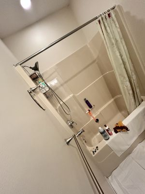 In-home dog grooming bathroom setup with a bathtub prepared with grooming supplies, towels, and pet-safe products