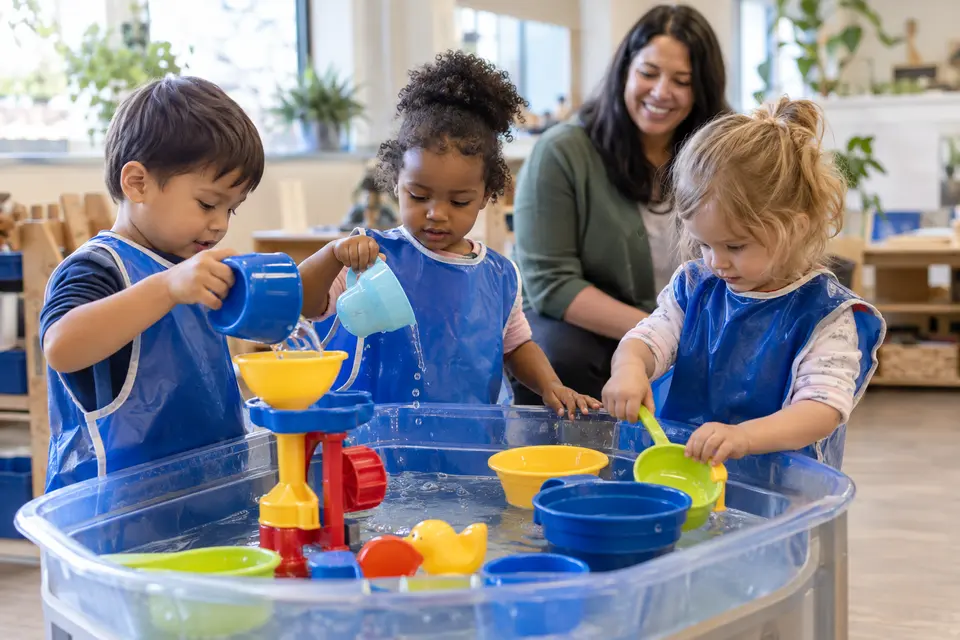 Young children exploring a supervised sensory water table