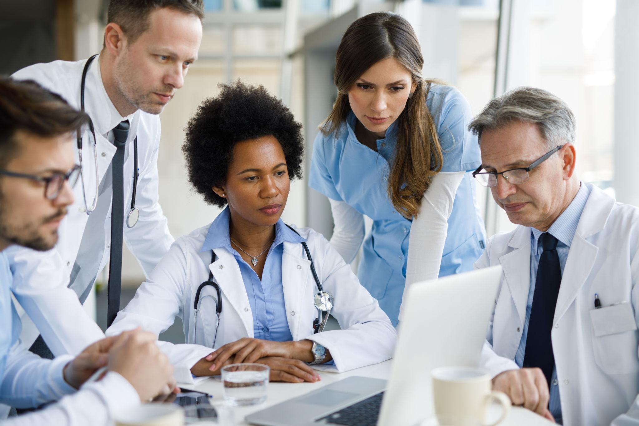 Healthcare professionals collaborating during a team meeting to identify challenges and evaluate healthcare supply chain solutions.