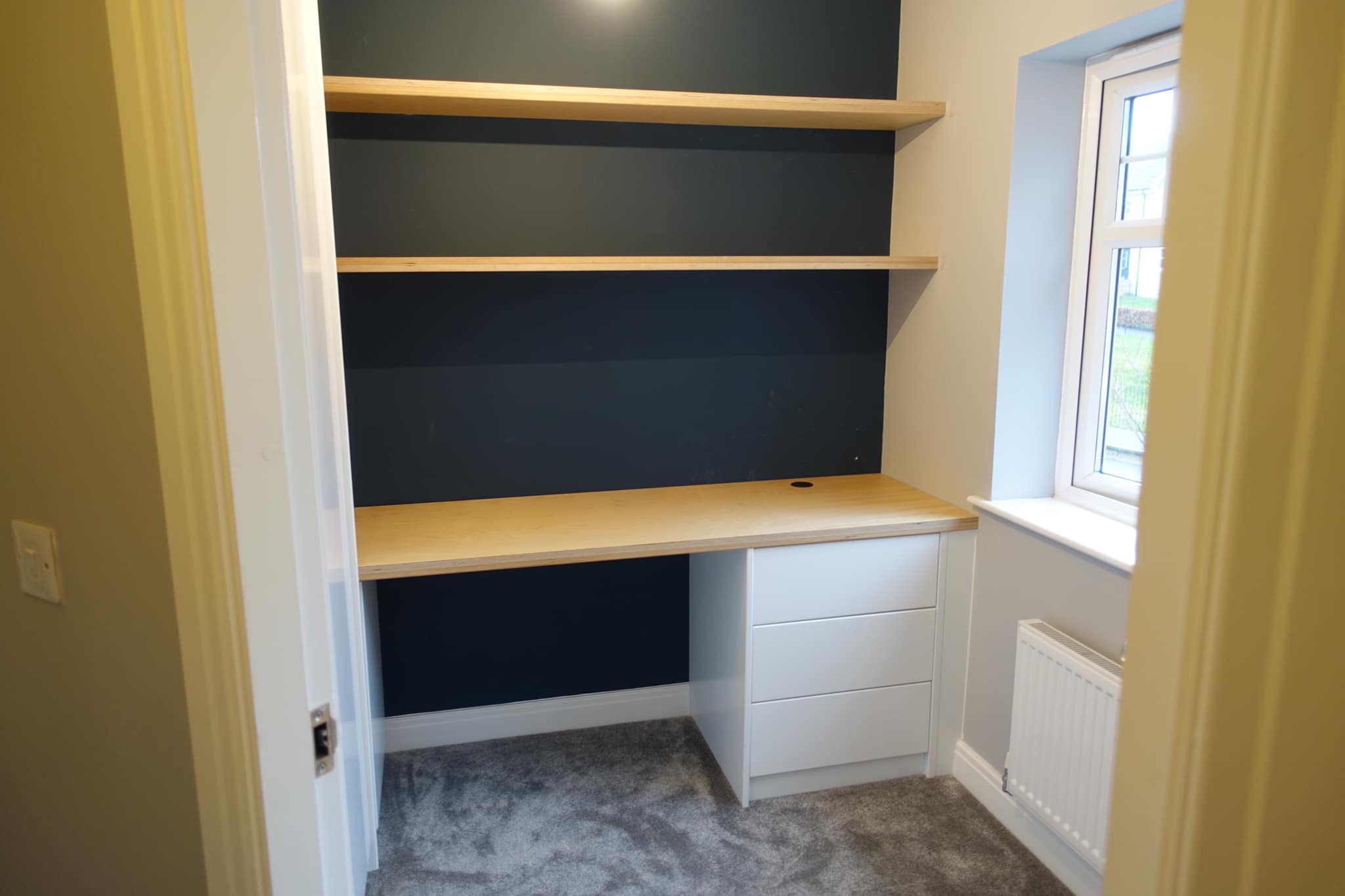 Bespoke home office with navy cabinetry, oak desk surface and integrated shelving in a Yorkshire home, by JAX Bespoke